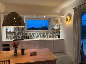 una cucina con tavolo e finestra di Villa Casa Bianca di Porto Selvaggio a Santa Caterina di Nardò