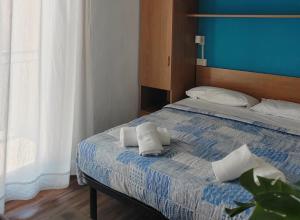 a bedroom with a bed with two towels on it at Hotel Luisa in Brenzone sul Garda