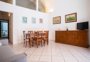 a living room with a table and chairs and a tv at Casetta Diana - The Fab Stay in Brindisi