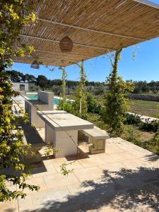 - une table de pique-nique sur une terrasse sous un toit dans l'établissement Villa Casa Bianca di Porto Selvaggio, à Santa Caterina