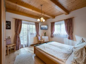 ein Schlafzimmer mit einem Bett in einem Zimmer mit Fenstern in der Unterkunft Ferienwohnungen Mitterer in Waidring