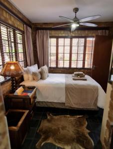 een slaapkamer met een bed en een plafondventilator bij Klein Bosveld Guest House in Witbank
