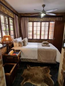 um quarto com uma cama e uma ventoinha de tecto em Klein Bosveld Guest House em Witbank