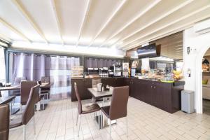 Un restaurante con una mesa y sillas y un mostrador. en Hotel Cesirja, en Casavatore