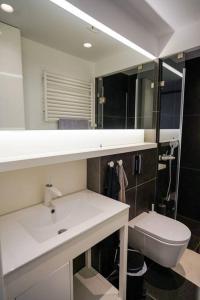 La salle de bains est pourvue d'un lavabo blanc et de toilettes. dans l'établissement GK Deluxe Studio Apartment, à Athènes