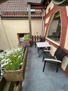 a patio with two chairs and a table and flowers at Gasthaus Zum Goldenen Hirsch in Schriesheim