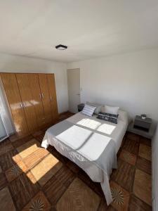 a bedroom with a large bed and wooden cabinets at Alojamiento temporal La Josefina in Tandil