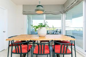 a dining room table with red chairs and a vase on it at Genteel Home Flamencos Terrace in Marbella