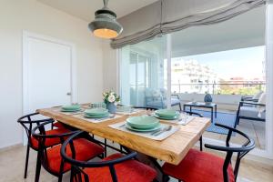 a dining room with a wooden table and chairs at Genteel Home Flamencos Terrace in Marbella