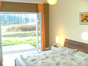 ヴェセンベルクにあるFerienwohnung am Heegeseeのベッドルーム1室(ベッド1台、大きな窓付)