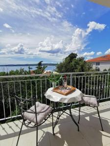 einen Tisch und Stühle auf einem Balkon mit Blick auf das Wasser in der Unterkunft Apartments Iva in Crikvenica