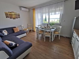 ein Wohnzimmer mit einem blauen Sofa und einem Tisch in der Unterkunft Apartments Iva in Crikvenica