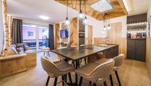 kuchnia ze stołem i krzesłami w obiekcie 24 by AvenidA - Mountain Hotel w Kaprunie
