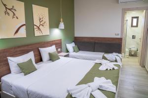 two beds in a room with green walls at Lafo Rooms in Elafonisi
