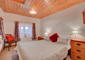 a bedroom with a bed and a wooden ceiling at Lukes House in Askrigg