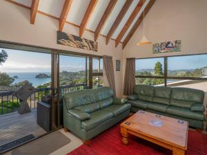 a living room with a couch and a table at Hahei Horizon - Hahei Holiday Home in Hahei