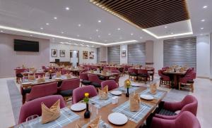 Click Hotel Aurangabad في أورانغاباد: مطعم فيه طاولات وكراسي في الغرفة