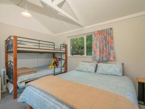 a bedroom with two bunk beds and a window at Hahei Horizon - Hahei Holiday Home in Hahei