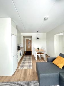 a living room with a blue couch and a kitchen at Kotimaailma Apartments Sairaalanrinne in Oulu