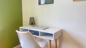 escritorio blanco con ordenador portátil y silla blanca en Le Vert’ueux - Appartement tout équipé à Niort en Niort