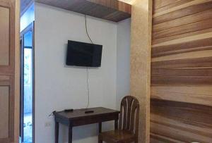 Habitación con mesa y TV en la pared. en RedDoorz @ Almari Beach Resort Tawi-Tawi 