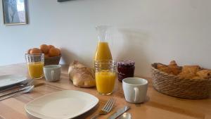 een tafel met een fles sinaasappelsap en brood bij Le Vert’ueux - Appartement tout équipé à Niort in Niort