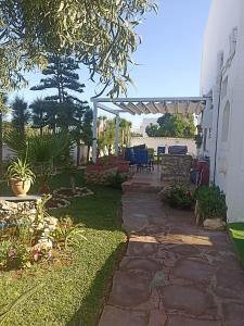 a backyard with a stone walkway and a pergola at Dar Mozart in Essaouira
