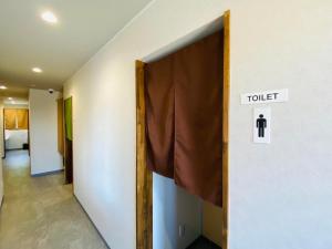 a door to a room with a toilet sign on a wall at chillout glamping zao in Zao