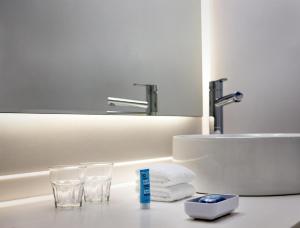 a bathroom with a sink and two glasses and a mirror at Aloft Birmingham Eastside in Birmingham +32 photos