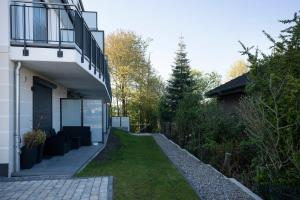 a house with a walkway next to a yard at Pier 67 Kleine Muschel in Neustadt in Holstein