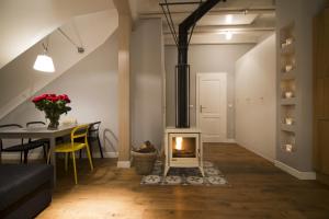 a fireplace in the middle of a living room with a table at Apartamenty Rynek3 , Kazimierz Dolny in Kazimierz Dolny