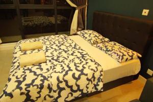 un letto con coperta e cuscini bianchi e neri di Bs115- KLIA- SELFCHECK-IN- WIFI- NETFLIX- PARKING- SEPANG, 5071 a Sepang