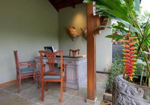 Habitación con mesa, sillas y escritorio. en JA Enchanted Waterfront Seychelles en Mahe