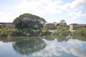 a view of a lake with buildings in the background at CHILL-OUT LAKESIDE - Wallis Lake Forster in Forster