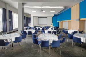 オストラヴァにあるQuality Hotel Ostrava Cityの白いテーブルと青い椅子が備わる会議室