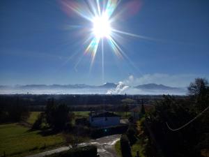 a sun shining in the sky over a field at Pyrenees Vue Gite - Vues Fantastique, Parking Gratuit Sur Place & Piscine in Saint-Gaudens