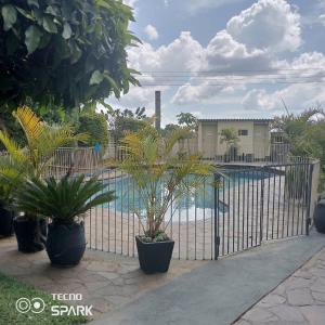 einen Zaun mit Pflanzen vor einem Pool in der Unterkunft Neat and cosy cottage with pool - 2103 in Harare