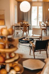 un salon avec des tables et des chaises ainsi qu'une salle à manger dans l'établissement le chalet de Plainpalais, à Les Déserts