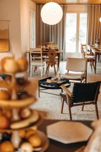 a living room with tables and chairs and a dining room at le chalet de Plainpalais in Les Déserts