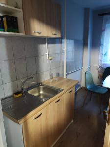 een keuken met een wastafel en een blauwe stoel bij Bo Apartment in Miercurea-Ciuc