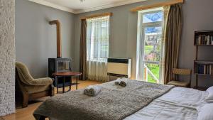 a bedroom with a bed and a large window at Kazbegi Green Yard in Kazbegi