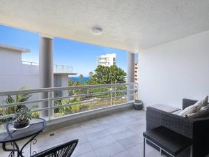 a living room with a balcony with a table and chairs at Lavish 3-bedroom ocean apartment in Wollongong in Wollongong
