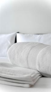 una pila di cuscini bianchi su un letto di Civico 18- La tua casa in centro a Latina