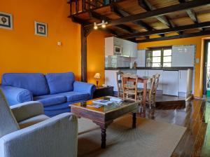 a living room with a blue couch and a table at Viviendas Rurales El Covaju in Cabezón de Liébana