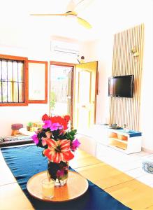 una sala de estar con un jarrón de flores sobre una mesa en La Morada (Gran Alacant) en Gran Alacant