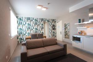 a living room with a couch and a kitchen at Mosella Suite Hotel in Sottomarina