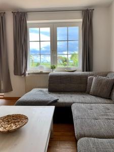 a living room with a couch and a large window at Sundblick, ideal für Familien in Teschendorf