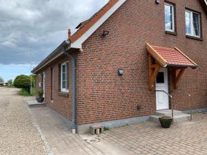 a brick house with a white door on a brick road at Sundblick, ideal für Familien in Teschendorf