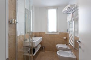 a bathroom with a sink and a toilet and a shower at Mosella Suite Hotel in Sottomarina