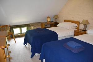 a bedroom with two beds with blue sheets at West Hollowcombe Farm Cottages - full site booking in Dulverton